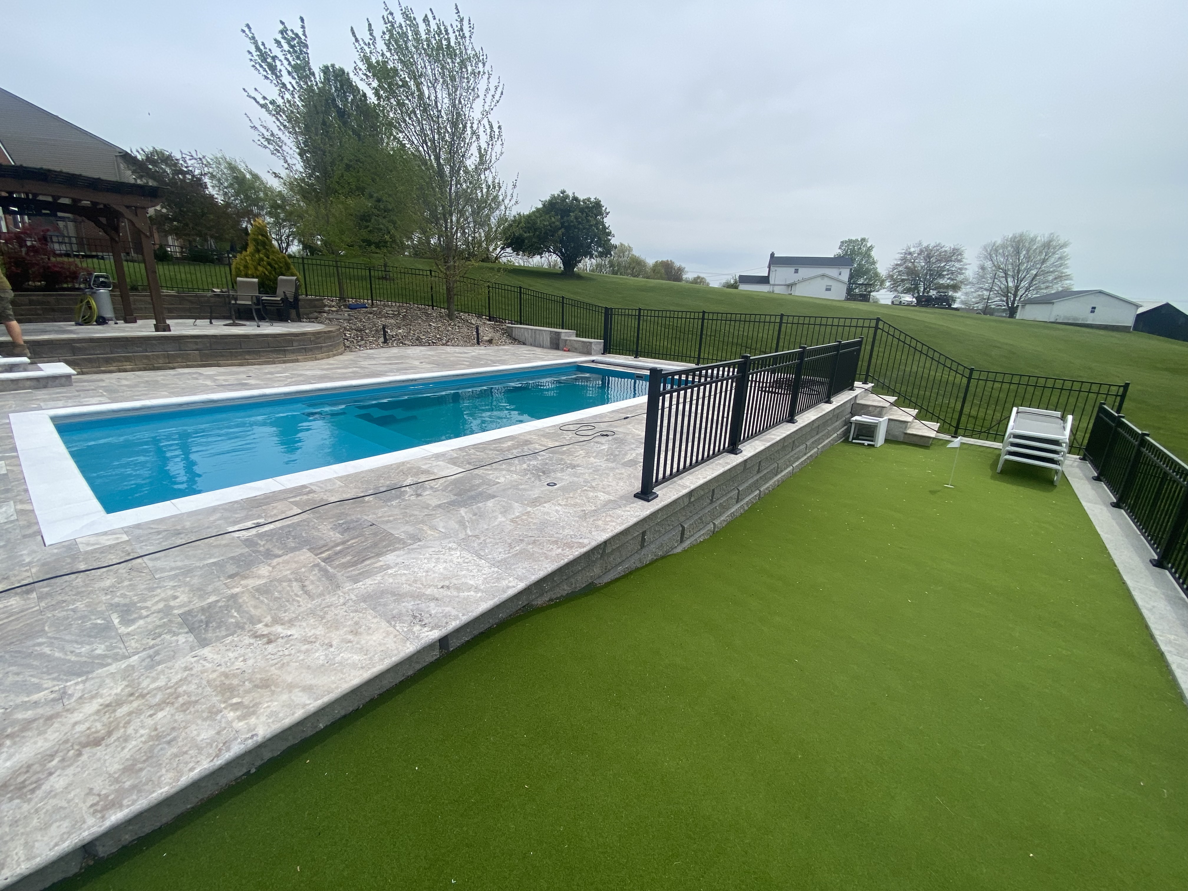 Completed pool project with stone surround by Oak Roots LLC Milan Indiana